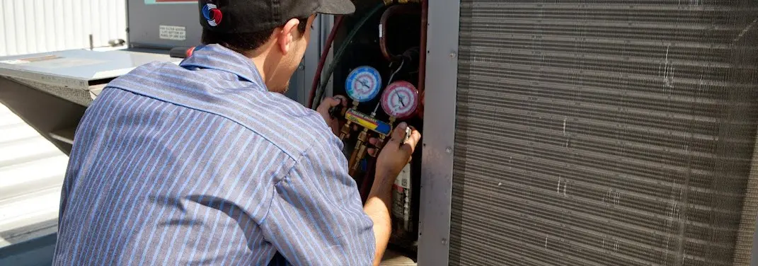 HVAC technician servicing a condenser unit in Makawao