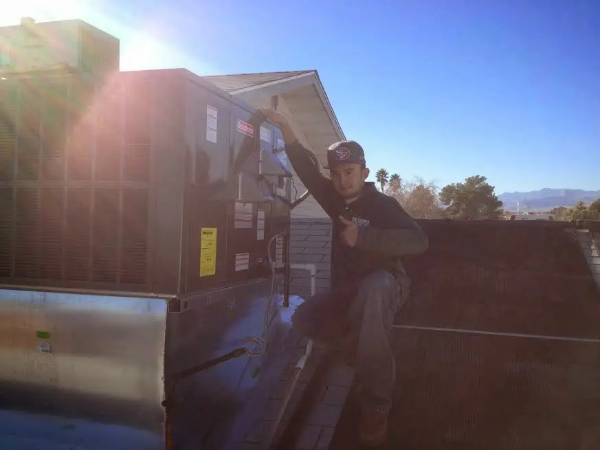 HVAC technician performing HVAC Inspection on a rooftop unit in Makawao